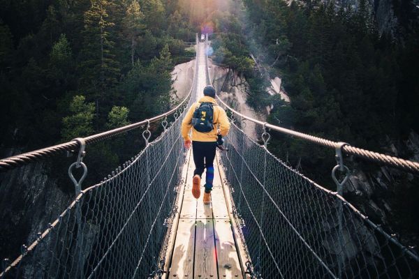 Person überquert eine Schlucht über eine lange Hängebrücke